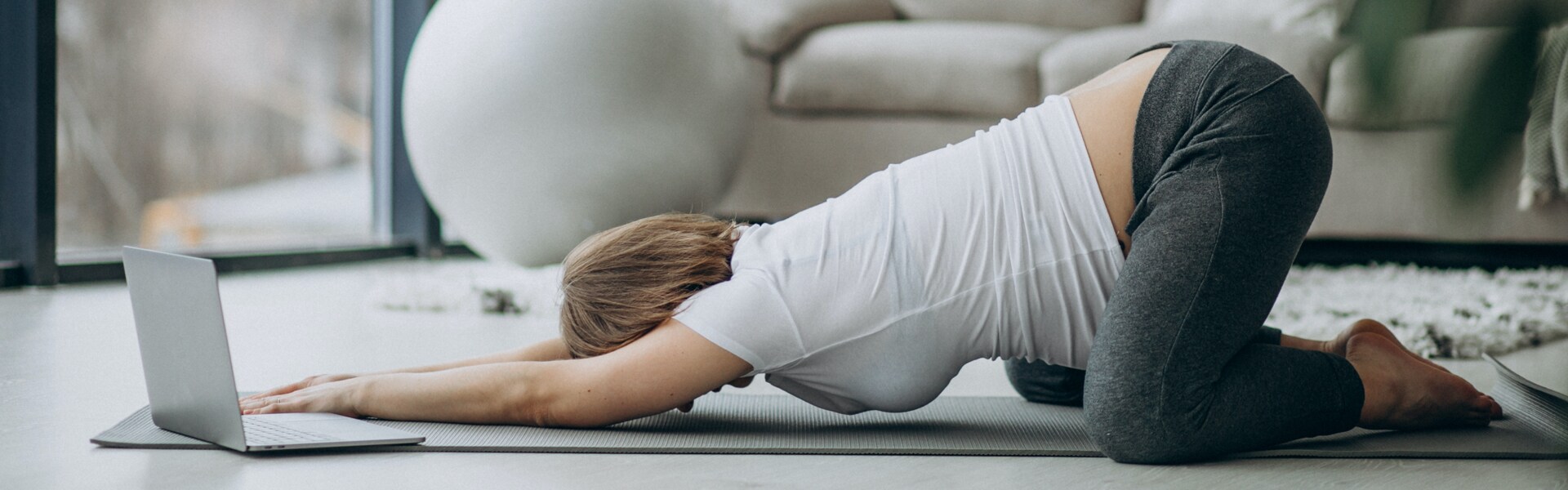 Schwangere Frau enspannt sich beim Yoga in der Stellung des Kindes