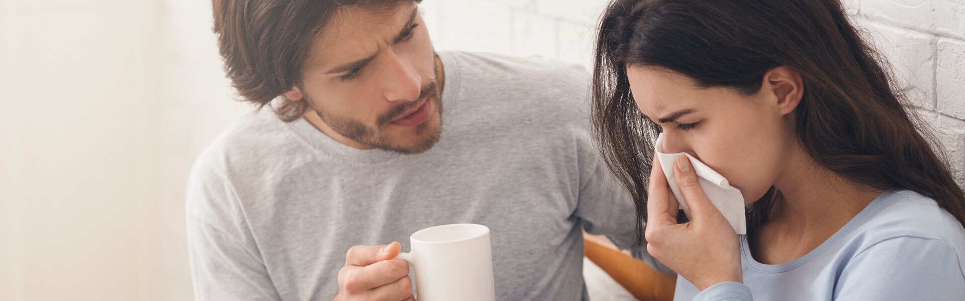 Schwangere Frau mit Allergie und ihr Mann auf dem Bett