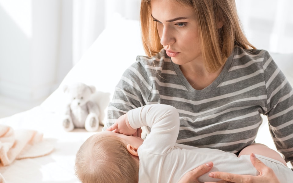 Mutter beruhigt Baby im Kinderzimmer